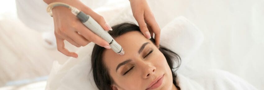 Dark-haired woman laying on the couch having laser resurfacing