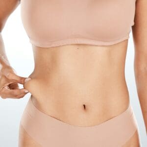 Model, hand or holding stomach fat for liposuction, weight loss or cosmetic surgery procedure on is