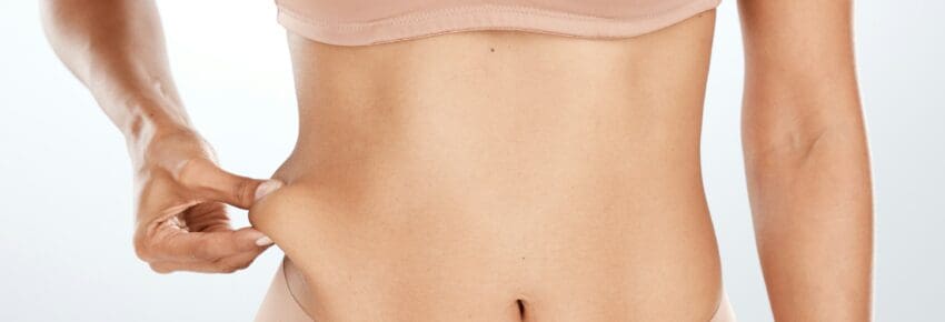 Model, hand or holding stomach fat for liposuction, weight loss or cosmetic surgery procedure on is