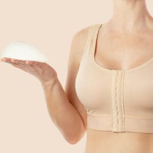 Woman wearing compressing bra after breast augmentation. Anatomical implants