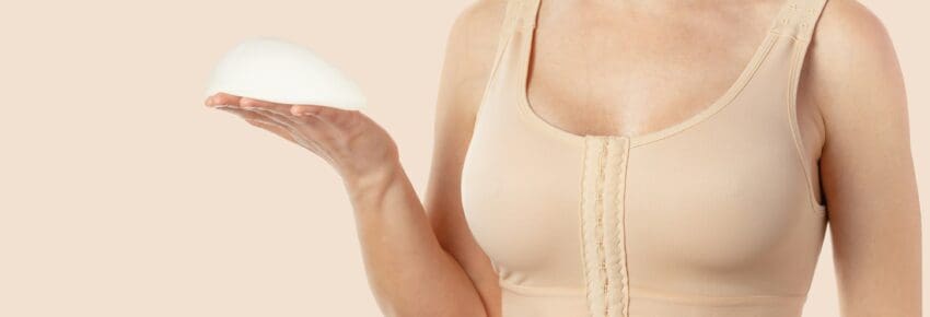 Woman wearing compressing bra after breast augmentation. Anatomical implants