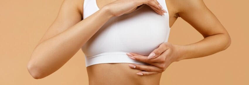 Young latin lady in white bra making breast self-screening, checkup for cancer prevention, standing