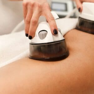 Cosmetologist makes buttock vacuum massage procedure for client closeup.