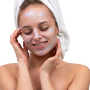 a young woman with a cosmetic mother-of-pearl color mask on her face closed her eyes in pleasure