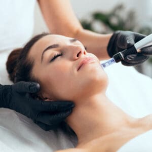 Cosmetologist making mesotherapy injection with dermapen on face for rejuvenation on the spa center.